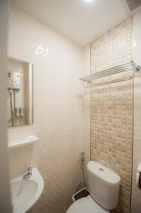 a bathroom with a white toilet and a sink at The Moon Night Hotel in Bangkok