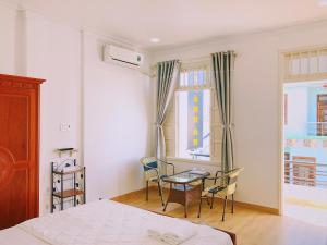 1 dormitorio con 1 cama, mesa y sillas en Hotel Khanh An en Phan Thiet