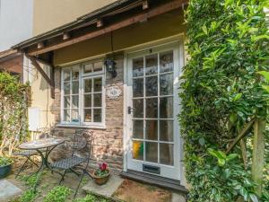 a brick house with a white door and a table at Old Town Cottage in Ludlow