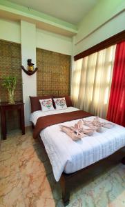 a bedroom with two beds with red curtains at Piscana Resort in Tayabas