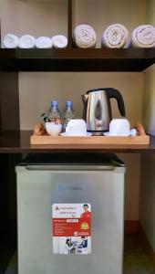 a shelf on top of a refrigerator with a tea kettle at Piscana Resort in Tayabas