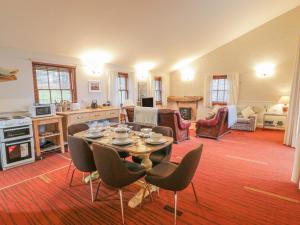 uma cozinha e sala de estar com mesa e cadeiras em Mercat Cottage em Port Seton