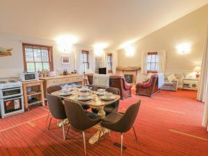 a kitchen and living room with a table and chairs at Mercat Cottage in Port Seton