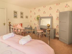 a bedroom with two beds with a mirror and a desk at Mercat Cottage in Port Seton