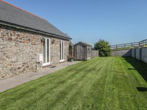 une grande cour à côté d'une maison en briques avec pelouse dans l'établissement Middle Barn, à Launceston