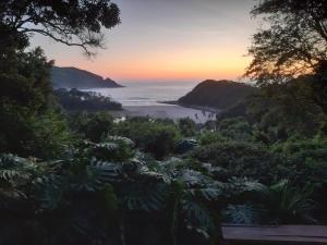a view of the beach at sunset from a hillside at Seaview Forest Cottage in Port St Johns