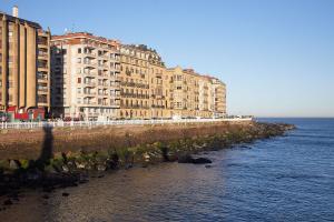 a row of buildings on the shore of the ocean at Marrubi - Basque Stay in San Sebastián