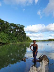 Eine Frau, die auf einem Felsen im Wasser steht in der Unterkunft Jungle Eco Reserve in Colón