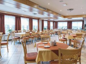 a dining room with tables and chairs and windows at Stiegenwirt in Palfau