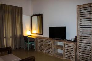 a room with a desk with a television and a mirror at Aayu Lagoon in Negombo