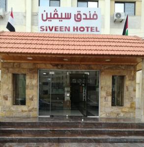 a hotel with a sign on top of a building at Siveen Hotel in Amman