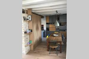 a kitchen and dining room with a table and chairs at Charmante maison rénovée en Pays de la Loire . in Durtal