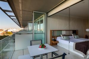 Schlafzimmer mit einem Bett und einem Tisch auf dem Balkon in der Unterkunft Parador de Cádiz in Cádiz
