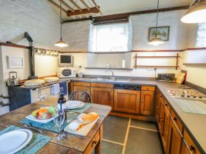 a kitchen with a table with a bowl of fruit on it at Mill Cottage in Staveley