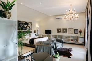 a bedroom with a bed and a chandelier at Casa Artista By Kresna Hospitality in Seminyak