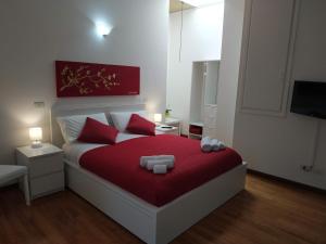 una camera da letto con un letto con lenzuola rosse e una coperta rossa di Loft VERDI Holiday Viterbo a Viterbo