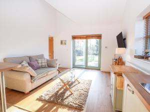 a living room with a couch and a table at Well View Cottage in Tarporley