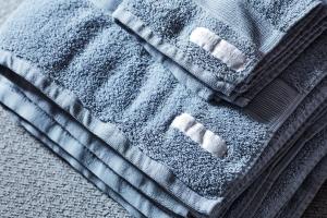 a blue towel on top of a bed at St Kilda Beachfront Penthouse in Melbourne