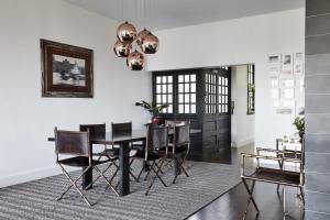 a dining room with a black table and chairs at St Kilda Beachfront Penthouse in Melbourne