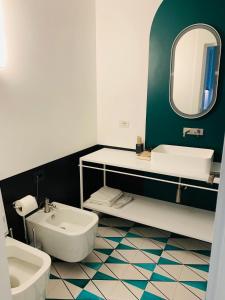 a bathroom with a sink and a toilet and a mirror at PrimoPianoPosillipo in Naples