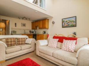 sala de estar con 2 sofás y cocina en Castlerigg, en Keswick