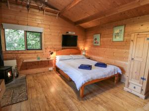 1 dormitorio con 1 cama en una cabaña de madera en The Log Cabin en Kilmore