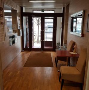 SUNRISE Hôtel في بروكسل: غرفة معيشة فيها باب وطاولة وكراسي