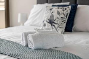 two towels sitting on top of a bed at Luxe 2 Bedroom Apartment in Barton in Kingston 