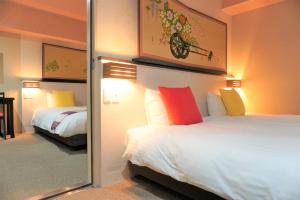 a hotel room with two beds and a mirror at Kyoto Inn Gion The Second in Kyoto