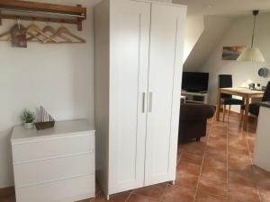 a white cabinet in a living room with a table at Kirchseeblick 5&6 in Kirchdorf