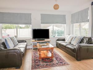 Una sala de estar con dos sofás y un televisor de pantalla plana. en Apartment 1, Trearren, en St. Agnes