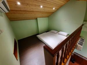 Cette petite chambre comprend un lit et un escalier. dans l'établissement Green Resort, à Wujie