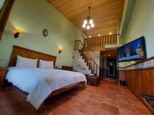- une chambre avec un grand lit et un escalier dans l'établissement Green Resort, à Wujie