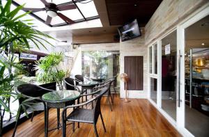 a restaurant with tables and chairs and a tv on the wall at The Key Bangkok Hotel in Bangkok