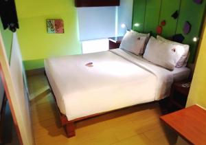 a white bed in a room with green walls at MaxOneHotels.com at Sabang in Jakarta