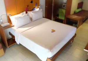 a bedroom with a large white bed with a wooden headboard at MaxOneHotels.com at Sabang in Jakarta