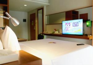 a room with a bed with a tv on the wall at MaxOneHotels.com at Sabang in Jakarta