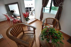 a dining room with two chairs and a table with flowers at Pavilion Inn in Miri