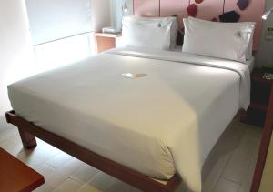 a large bed with white sheets and pillows at MaxOneHotels.com at Sabang in Jakarta