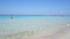 a man standing in the water at the beach at Appartamenti Baia Verde Gallipoli di Carlino Tourist in Gallipoli +7 photos