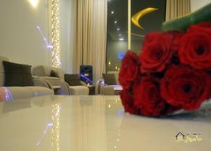 a vase of red roses sitting on top of a table at Masurat Chalet in Riyadh