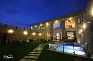 una casa con piscina por la noche en Masurat Chalet, en Riad
