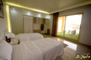 a hotel room with two beds and a large window at Masurat Chalet in Riyadh