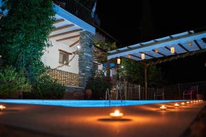 Laroya的住宿－皮卡西奧鄉村旅館，夜晚在游泳池里放一排蜡烛
