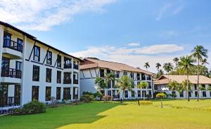 a large building with a lawn in front of it at Nirwana Resort Hotel in Lagoi