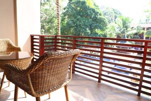 a balcony with wicker chairs and a table at Sea Shell Samssara in Neil Island