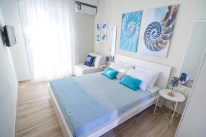 a bedroom with a bed with blue and white pillows at Sea Breeze Vibes in Nea Peramos