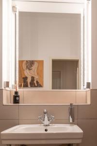 ein Bad mit einem Waschbecken und einem Spiegel in der Unterkunft Hotel Olympic in München