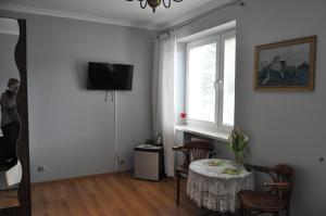a living room with a table and a window at J&T Pokoje Wczasowe in Kołobrzeg
