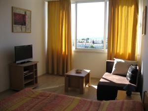 1 dormitorio con 1 cama, TV y ventana en Studio The Sun, en Dubrovnik